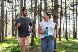 An inspiring scene unfolds as a beautiful, overweight female embarks on a jog in the park with her dedicated partner, embracing their journey to better health.