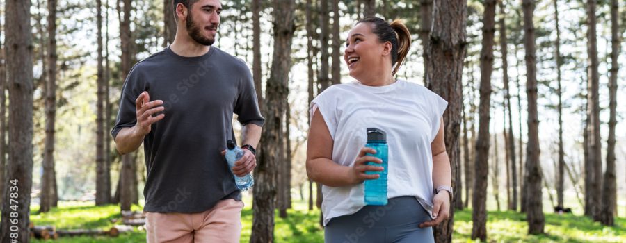 An inspiring scene unfolds as a beautiful, overweight female embarks on a jog in the park with her dedicated partner, embracing their journey to better health.