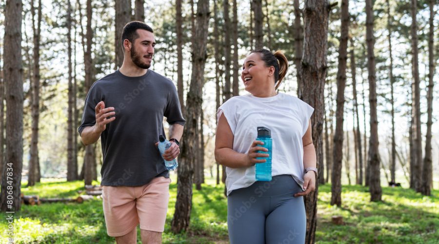 An inspiring scene unfolds as a beautiful, overweight female embarks on a jog in the park with her dedicated partner, embracing their journey to better health.